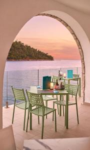 a table and chairs on a balcony with a view of the ocean at Aminess Lume Hotel in Brna