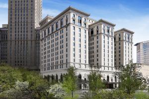 a large white building in a city with tall buildings at Hotel Cleveland Autograph Collection in Cleveland