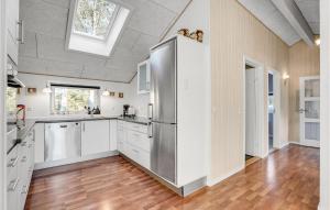 a kitchen with white cabinets and a stainless steel refrigerator at Holiday Home Hybenvangen Oksbøl Denm in Oksbøl