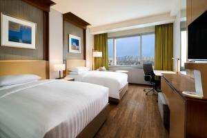 a hotel room with two beds and a desk at Courtyard By Marriott Seoul Times Square in Seoul