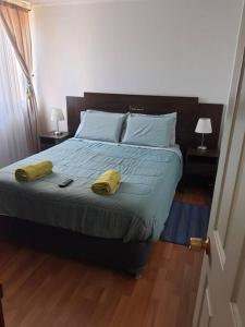 a bedroom with a bed with two yellow towels on it at Departamento en Iquique A pasos de playa Cavancha in Iquique +10 photos