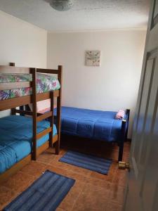 a room with two bunk beds and a blue bed at Departamento en Iquique A pasos de playa Cavancha in Iquique