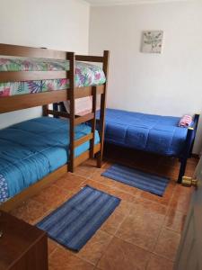 a room with two bunk beds and two blue mats at Departamento en Iquique A pasos de playa Cavancha in Iquique