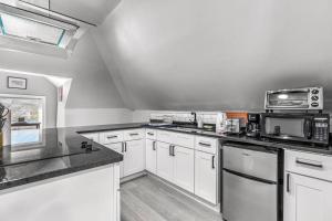 a kitchen with white cabinets and white appliances at 3rd Story Loft Islandview Pets Included with Free Parking! in Detroit