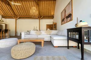 a living room with a white couch and a table at Villa Manouch in Nusa Lembongan