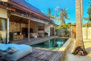 a villa with a swimming pool and a house at Villa Manouch in Nusa Lembongan