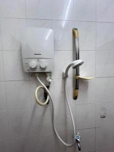 a shower in a bathroom with a hose on a wall at Villa near Adda Heights Yi Jia Restaurant with KTV Mini Theatre Swimming Pool n Pool Table in Johor Bahru