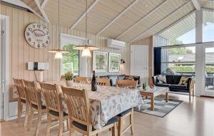 una sala da pranzo con tavolo, sedie e orologio di Holiday Home Østmarken Toftlund Ix ad Arrild