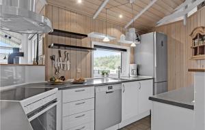 una cucina con elettrodomestici bianchi e pareti in legno di Holiday Home Østmarken Toftlund Ix ad Arrild