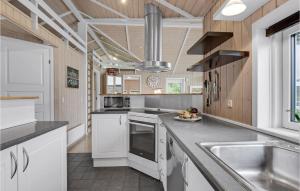 una cucina con mobili bianchi e un lavandino di Holiday Home Østmarken Toftlund Ix ad Arrild Altre 17 foto