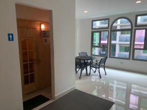 a hallway with a table and chairs in a building at Arcadia beach 网红水系公寓一房 Nice view 专业的健身房 桑拿 中心位置 交通便利 Smart tv WiFi in Pattaya South