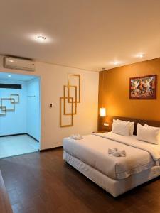a hotel room with a large bed and a door at Hotel Ompu Herti in Balige