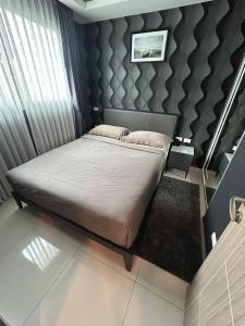 a bedroom with a large bed with a wall at Arcadia beach 网红水系公寓一房 Nice view 专业的健身房 桑拿 中心位置 交通便利 Smart tv WiFi in Pattaya South +37 photos