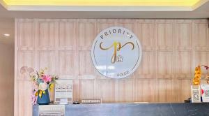 a sign on a wooden wall with flowers on a counter at Priority Kalimantan Samarinda in Samarinda