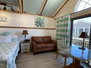 a bedroom with a bed and a chair and a glass table at NC 12 56821-37 Condo in Hatteras