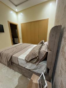 a bedroom with a bed and a chair at CASA BAY BEACH OMK 2 in Sidi Rahal +18 photos