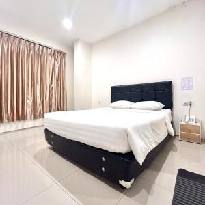 una camera da letto con un letto grande e una finestra di Priority Guest House Samarinda a Samarinda