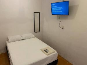 a room with a bed with a tv on the wall at Hermoso y Cómodo Departamento in Ciudad del Carmen