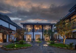 an exterior view of a building at night at Mount Emei Heyuan Serene Residence Hot Spring Hotel in Emeishan City