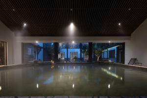 an indoor swimming pool in a house at night at Mount Emei Heyuan Serene Residence Hot Spring Hotel in Emeishan City