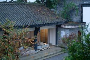 an outside view of a small building with a window at Mount Emei Heyuan Serene Residence Hot Spring Hotel in Emeishan City