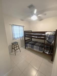 Cette chambre comprend 2 lits superposés et un tabouret. dans l'établissement Casa Historica, a cozy 1940 cottage in Delray Beach, FL, à Delray Beach
