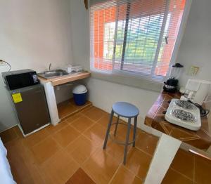 eine Küche mit einem Herd und einem Stuhl in einem Zimmer in der Unterkunft Hermoso y Cómodo Departamento in Ciudad del Carmen