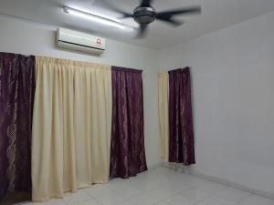a living room with curtains and a ceiling fan at BERTAM KEPALA BATAS GUEST HOUSE for Male ONLY in Kepala Batas