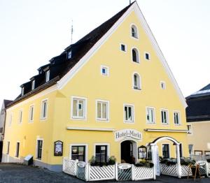 ein großes gelbes Gebäude mit einem Schild drauf in der Unterkunft Hotel am Markt in Greding