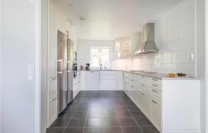 una cucina con armadietti bianchi e pavimento piastrellato di Stunning Home In Lidhult With Wifi a Lidhult