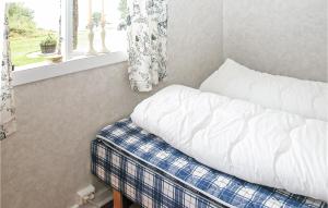 an unmade bed with a pillow and a window at Nice Home In Etne With House Sea View in Børkjenes