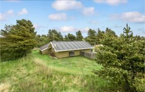 a house in the middle of a field with trees at Holiday Home Ringvejen Rømø I in Bolilmark +19 photos