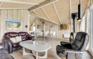 a living room with leather furniture and a table at Holiday Home Ringvejen Rømø I in Bolilmark