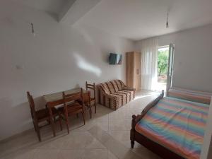 a bedroom with a bed and a table and a chair at Apartments Ivana in Ulcinj