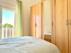 a bedroom with a bed and a closet and a window at Apartment Elaine's View in Umag