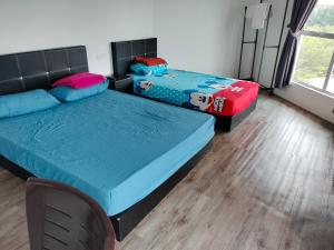 a bedroom with two beds and a chair at BENUTHOMESTAY in Johor Bahru +9 photos