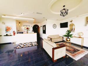 a living room with a couch and a tv at The Blossom Hotel in Simpang Empat