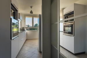 eine Küche mit weißen Geräten und einem Fenster in der Unterkunft Charmant Appartement Familial in Martigues