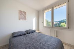 ein Schlafzimmer mit einem Bett mit zwei Kissen darauf in der Unterkunft Charmant Appartement Familial in Martigues