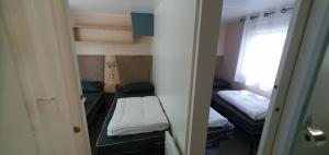 een kleine kamer met twee bedden en een raam bij MH 3ch calme Bois Dormant accueil personnalisé in Saint-Jean-de-Monts +41 foto's