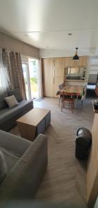 een woonkamer met een bank en een tafel bij MH 3ch calme Bois Dormant accueil personnalisé in Saint-Jean-de-Monts