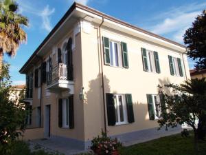 カッラーラにあるB&B Rossanaの白い家(緑のシャッター、バルコニー付)