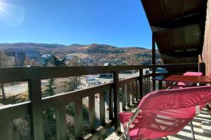 een roze stoel op een balkon met uitzicht bij Appartement le Dahu Risoul 1850 in Risoul