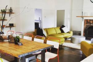 a living room with a couch and a table and chairs at Temora House in Healesville