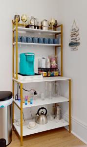 a shelf filled with dishes and utensils at 15 Minutes to NYC - Garden Street Retreat in Hoboken +48 photos