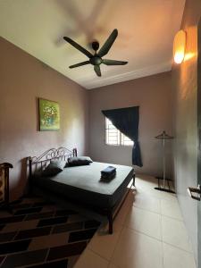 a bedroom with a bed with a ceiling fan at Taiping Homestay Husna Afina in Taiping