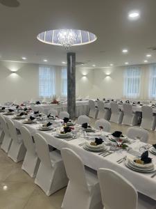 a large banquet hall with white tables and white chairs at Apartmány Buková in Kežmarok