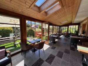 a dining room with tables and chairs and windows at Pension Lambrecht in Sankt Lambrecht