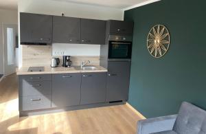 a kitchen with gray cabinets and a sink at Ferienwohnung Eulenflucht in Hameln