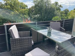 a balcony with a glass table on a roof at Ferienwohnung Eulenflucht in Hameln